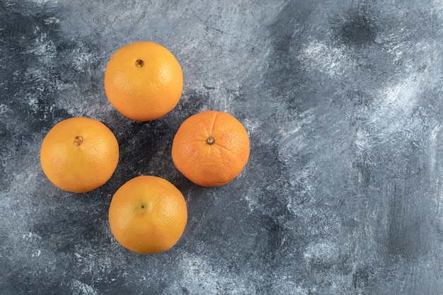 Photo gratuite quatre oranges savoureuses sur table en marbre.