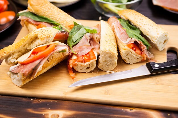 Quatre sandwichs faits maison sur planche de bois en photo studio