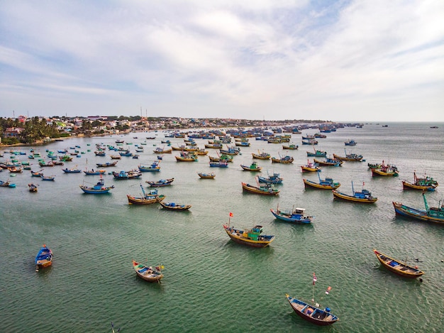 Que de bateaux sur cette plage, mui ne, vietnam. par une journée ensoleillée dans le sud du vietnam, une foule de bateaux de pêcheurs revenant de la pêche en attente d'entrer sur le quai. paysage vue de dessus aérienne.