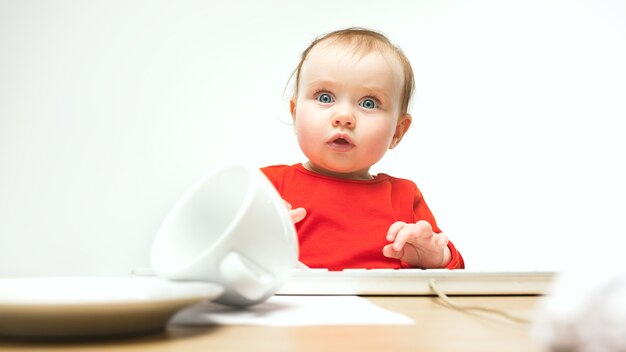 Quel enfant surpris bébé fille assise avec clavier d'ordinateur ou ordinateur portable moderne en blanc