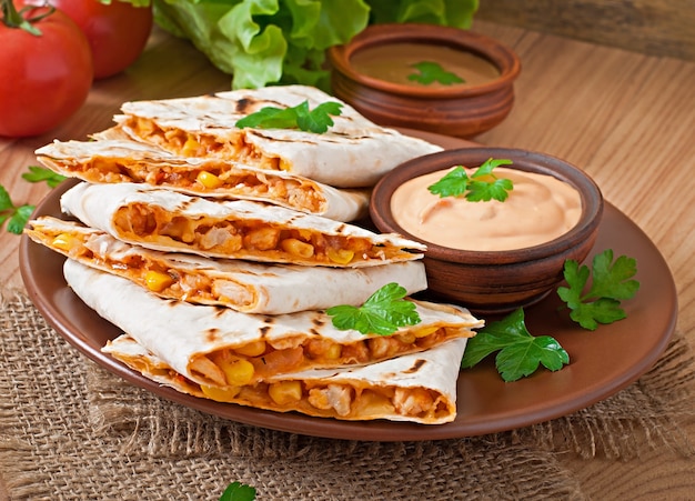 Photo gratuite quesadilla mexicaine en tranches avec des légumes et des sauces sur la table