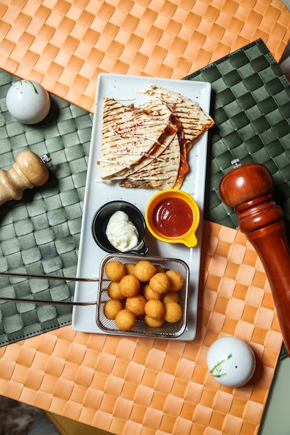 Photo gratuite quesadilla à la viande avec fromage, haricots, sauce tomate et boulettes de pommes de terre