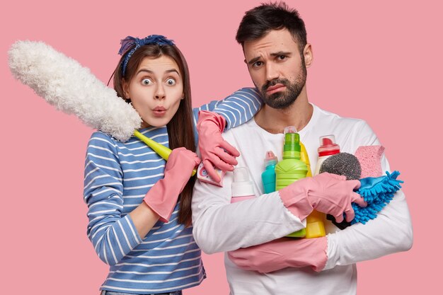 Équipe amicale du service de nettoyage occupé avec une session de nettoyage de la maison, laver les murs de leur appartement