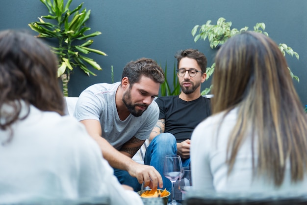 Équipe d'amis appréciant le vin et les collations