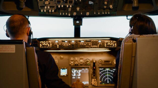 Équipe d'aviateurs utilisant les boutons du tableau de bord pour décoller avec l'avion, démarrer le moteur électrique et la navigation du panneau de commande. Vol d'aviation avec boussole radar et interrupteur à levier de pare-brise.