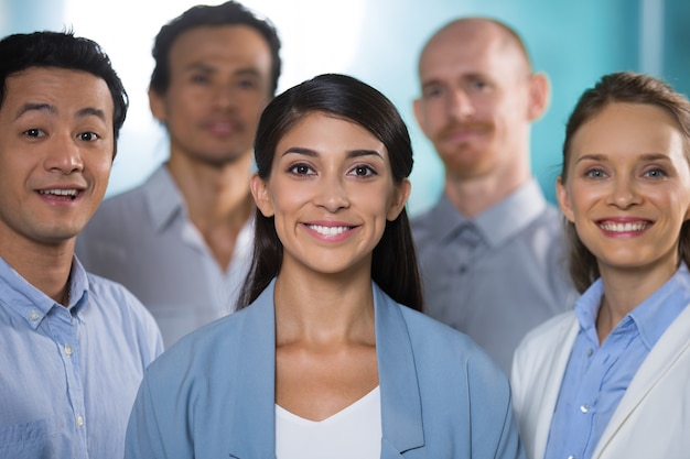 Équipe commerciale prospère souriante à la caméra