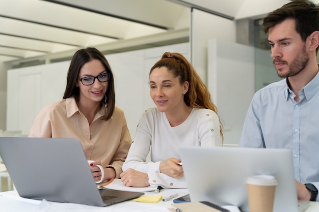 Équipe commerciale travaillant ensemble au bureau avec ordinateur portable