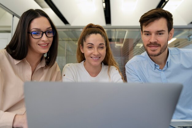 Équipe commerciale travaillant ensemble au bureau avec ordinateur portable