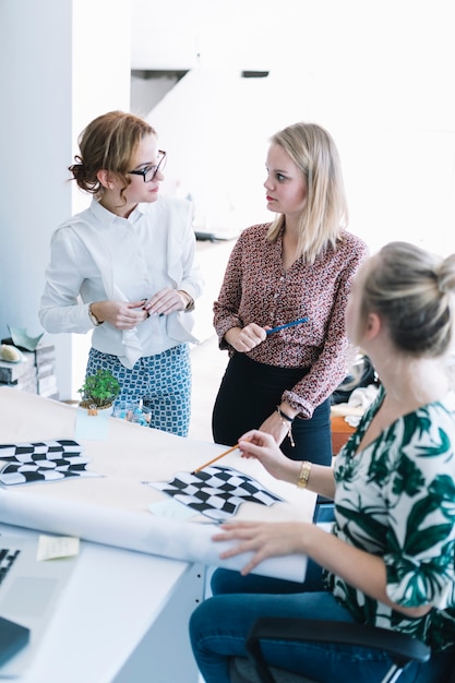 Équipe créative de femmes d&#39;affaires préparant un drapeau à damier au bureau