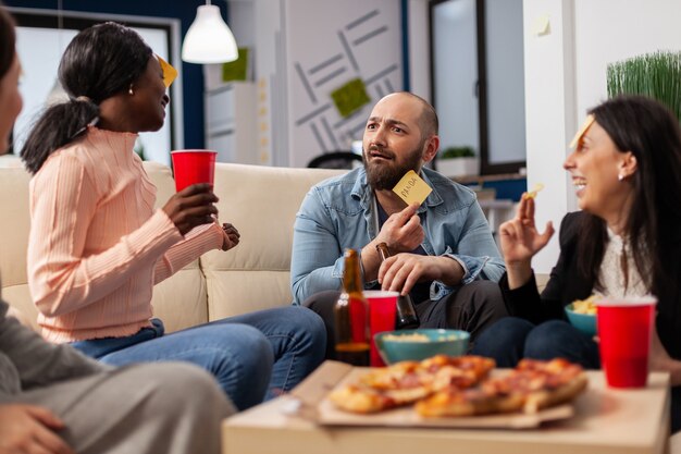 Équipe diversifiée de collègues jouant des charades après le travail