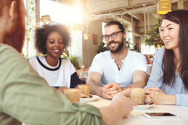 Équipe de jeunes collègues ayant une réunion au café