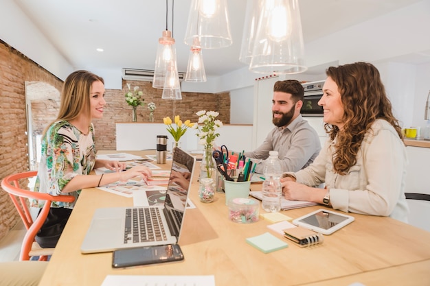 Équipe joyeuse travaillant avec des papiers et des gadgets