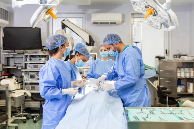 Équipe de médecins professionnels effectuant une opération dans une salle d'opération Équipe médicale effectuant une opération chirurgicale dans une salle d'opération moderne et lumineuse