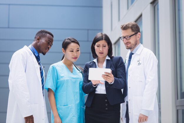 Équipe de médecins à la recherche de tablette numérique