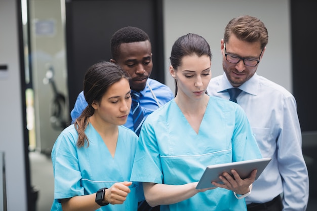 Équipe médicale discutant sur tablette numérique