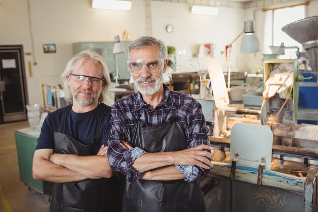 Équipe de souffleurs de verre avec les bras croisés