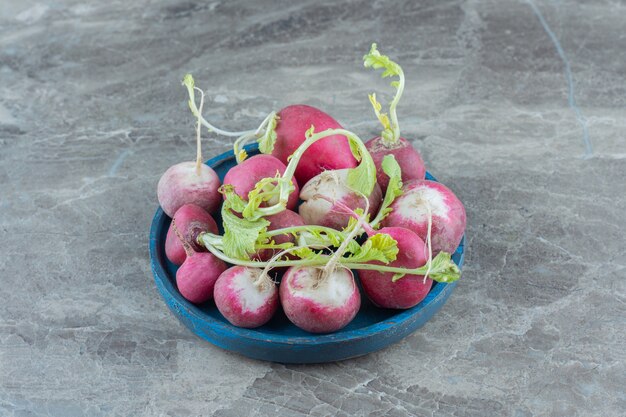 Radis délicieux dans le bol, sur la table en marbre.