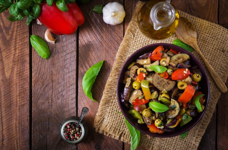 Photo gratuit ragoût d'aubergine épicé chaud, poivron, olives et câpres avec des feuilles de basilic. vue de dessus