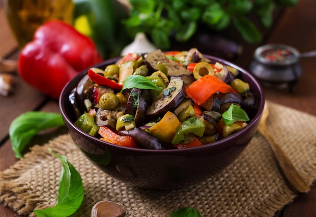 Ragoût d'aubergine épicé chaud, poivron, olives et câpres avec des feuilles de basilic.