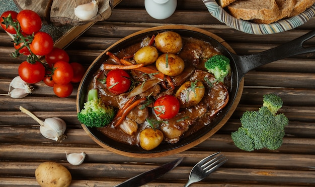 Ragoût de boeuf aux légumes vue de dessus dans une casserole en poterie.