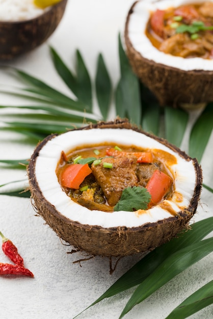 Photo gratuite ragoût dans des assiettes de noix de coco avec des feuilles