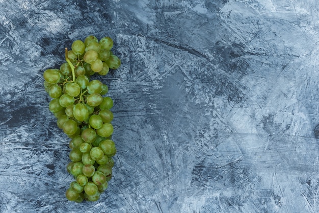 Raisins blancs à plat sur fond de marbre bleu foncé. horizontal