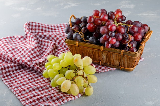 Raisins dans un panier sur toile de pique-nique et plâtre. vue grand angle.