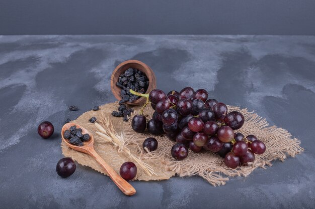 Raisins frais et mûrs et cuillère sur toile de jute.