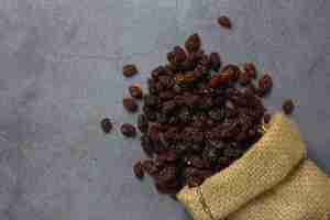 Photo gratuite raisins secs en bagl de toile de jute sur table