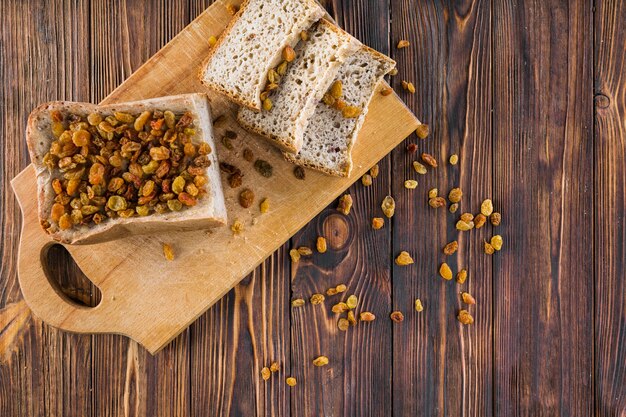 Raisins sur les tranches de pain sur la planche à découper sur la table