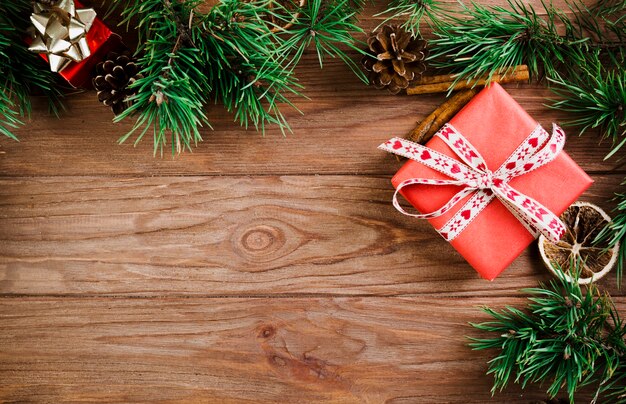 Rameau de Noël et boîtes à cadeaux sur une planche en bois