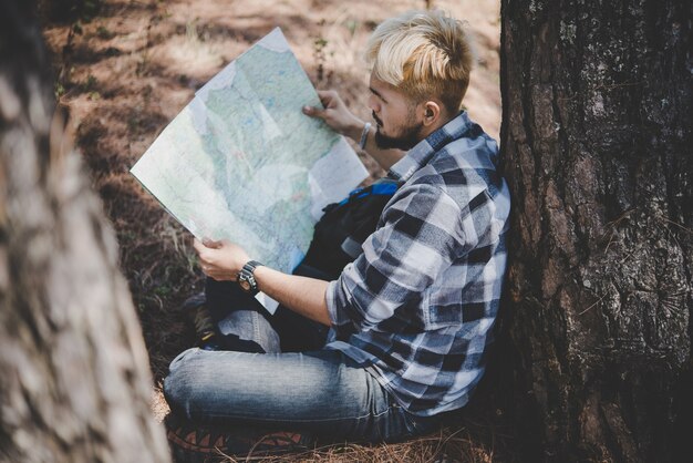 Randonnée relaxante par un arbre en regardant la carte, faites de l&#39;aventure en montagne.