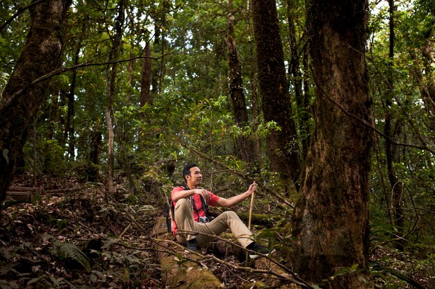 Randonneur assis sur une colline dans la jungle