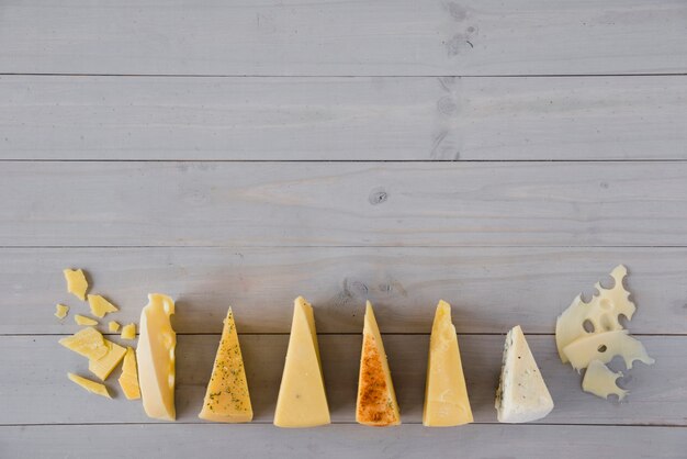 Rangée de fromage triangulaire sur un bureau en bois gris