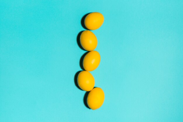 Rangée d&#39;oeufs de Pâques jaunes sur la table