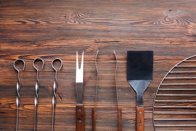 Rangée d&#39;ustensiles de barbecue sur une table en bois