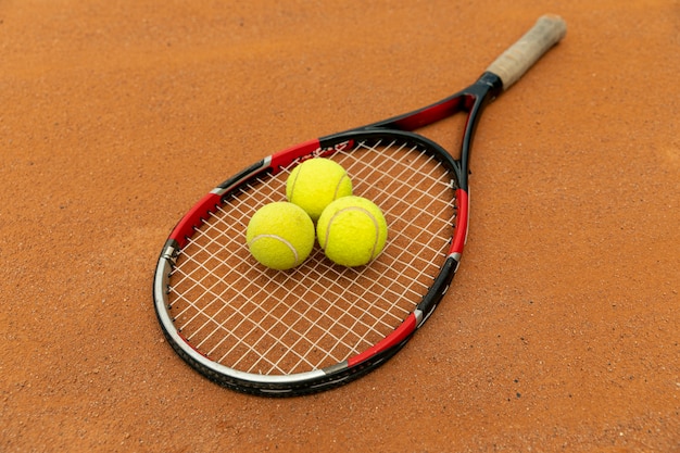 Raquette haute vue et balles de tennis sur terrain