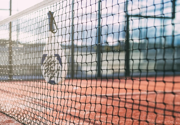 Raquette de padel accrochée au filet