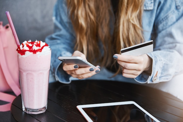 Recadrée de jeune femme aux cheveux blonds, tenant un smartphone