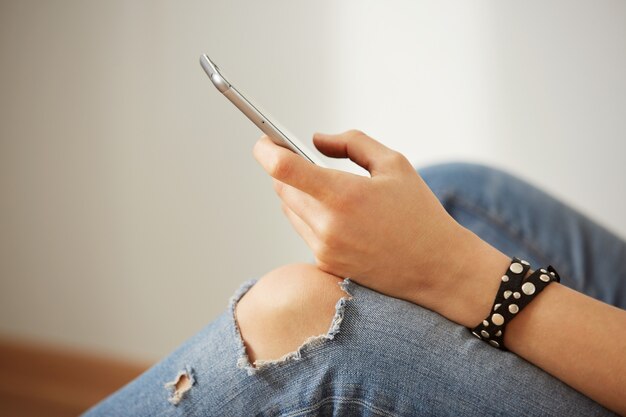 Recadrée vue sur les mains d'une femme tenant un téléphone mobile