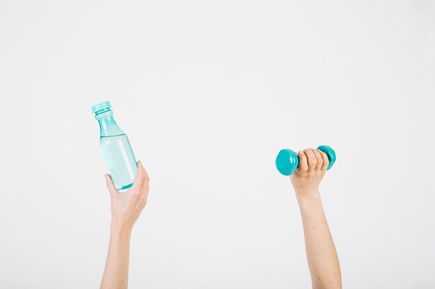 Recadrer les mains avec une bouteille et haltère