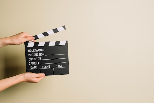 Photo gratuite recadrer les mains avec clapperboard