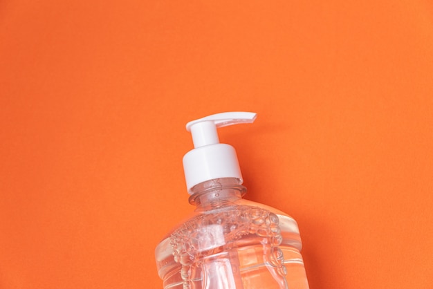 Récipient avec gel d'alcool sur le mur orange