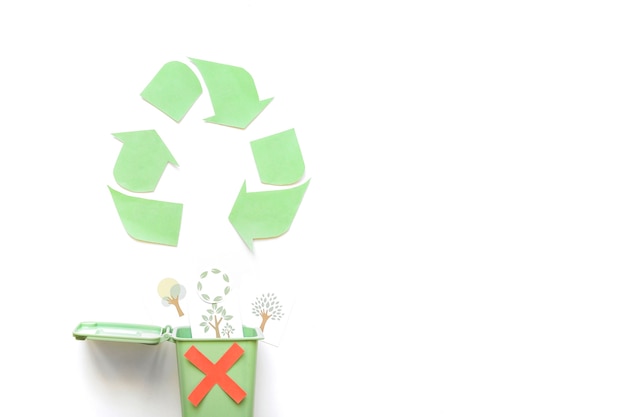 Photo gratuite recycler le logo près de la poubelle avec des dessins de verdure