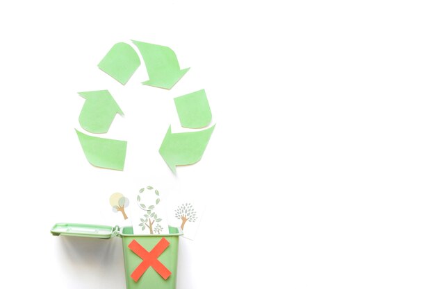 Recycler le logo près de la poubelle avec des dessins de verdure