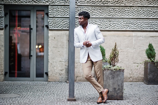 Réfléchi jeune beau gentleman afro-américain en tenues de soirée Homme modèle élégant noir en veste blanche