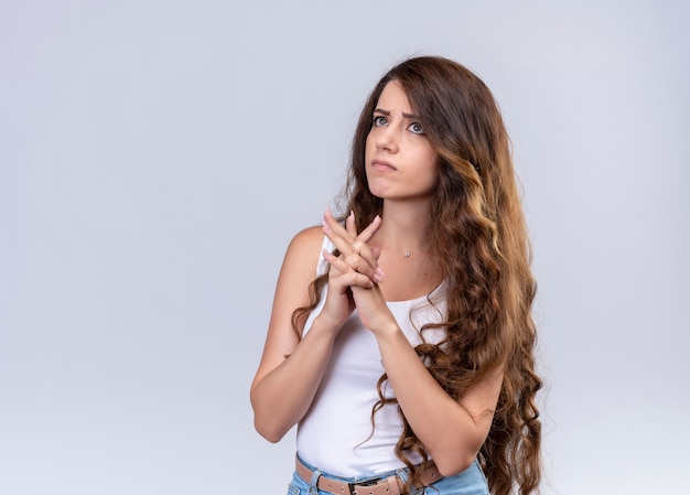 Réfléchi jeune belle fille mettant les mains ensemble en levant sur un mur blanc isolé avec copie espace