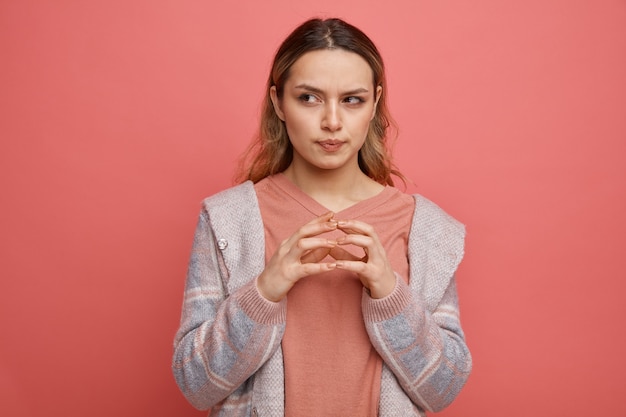 Photo gratuite réfléchi jeune fille gardant les mains ensemble à côté