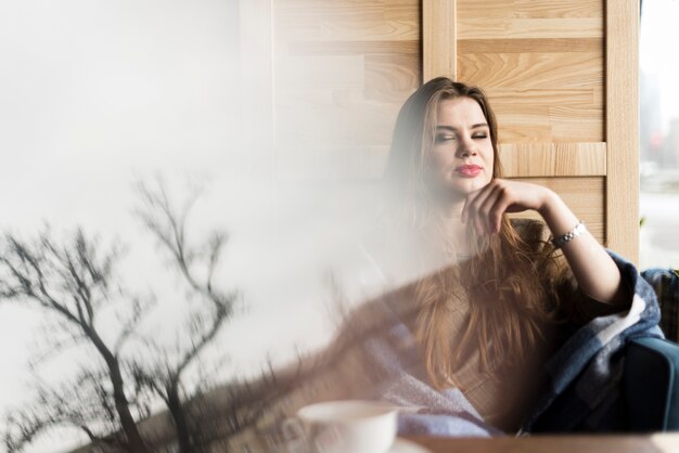 Réflexion d&#39;un arbre avec une fille détendue en arrière-plan