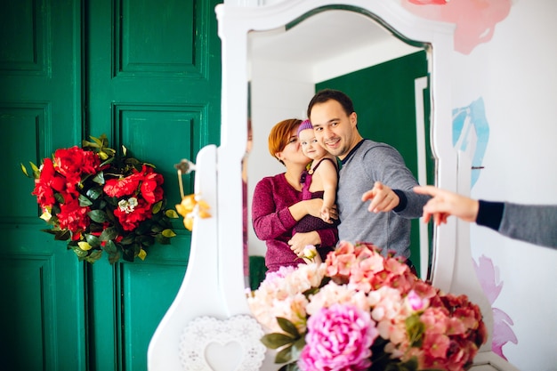 Réflexion de parents heureux avec petite fille en miroir blanc